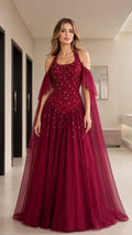 Front view of model wearing burgundy halter sequin tulle evening gown with cape sleeves