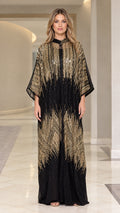Front full-length view of woman wearing black and gold sequin kaftan maxi dress