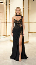 Front view of model wearing black strapless lace corset draped maxi gown with high slit and neck scarf