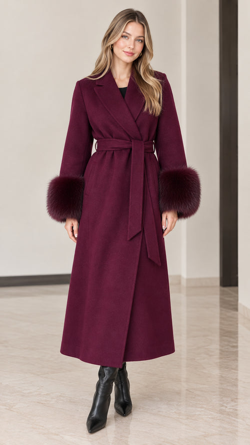 Full front view of model wearing burgundy maxi wrap coat with faux fur cuffs and tie belt
