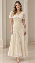 Front view of woman wearing champagne floral lace V-neck maxi dress with beaded flutter sleeves