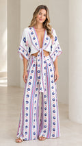 Full front view of model wearing white floral print tie-front crop top and wide-leg pants two-piece set