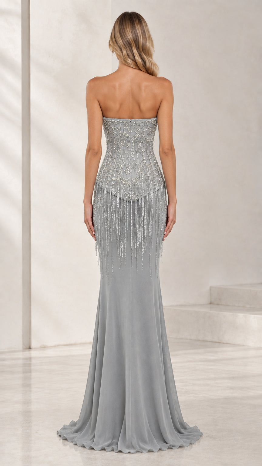 Back view of model wearing strapless floor-length silver gray formal dress