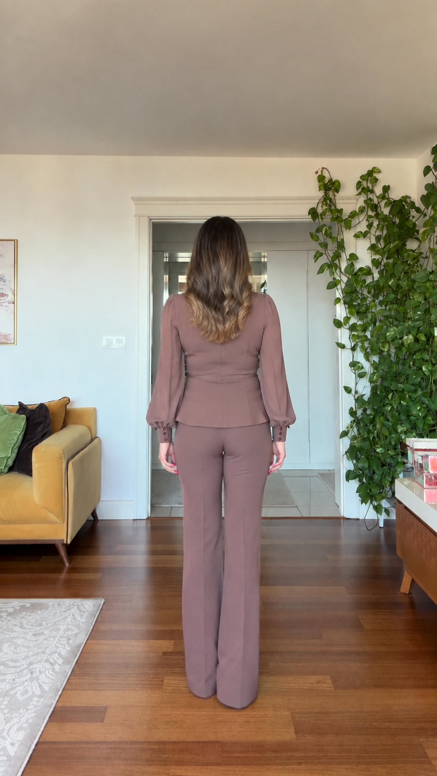 Back view of woman wearing mauve long-sleeve blazer and matching trousers