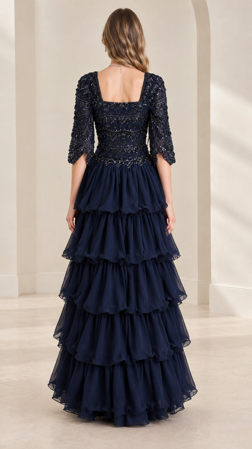 Back view of navy blue beaded square neck evening gown with cascading ruffles