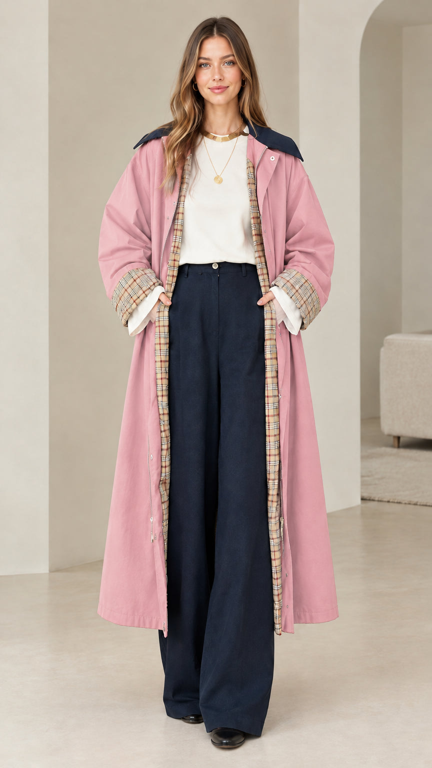Front view of model wearing dusty pink long duster trench coat with plaid trim